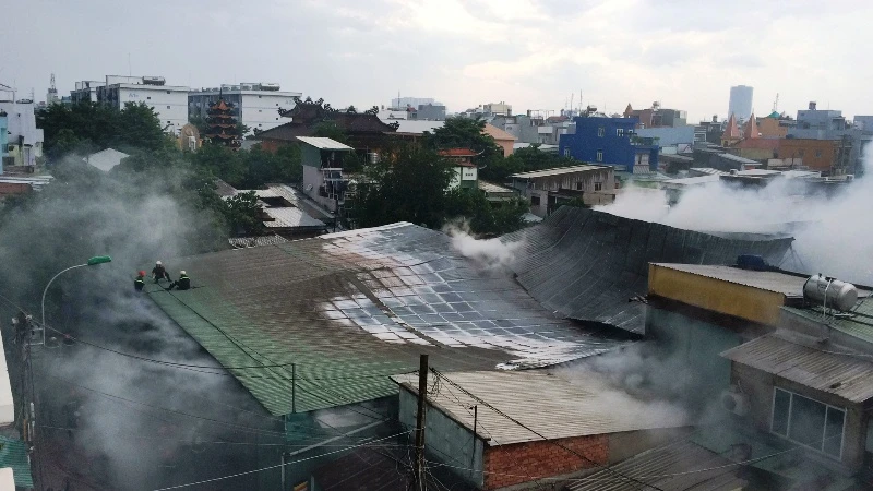 Lực lượng cảnh sát PCCC phải đục tường, mái tôn để tiếp cận điểm hỏa.